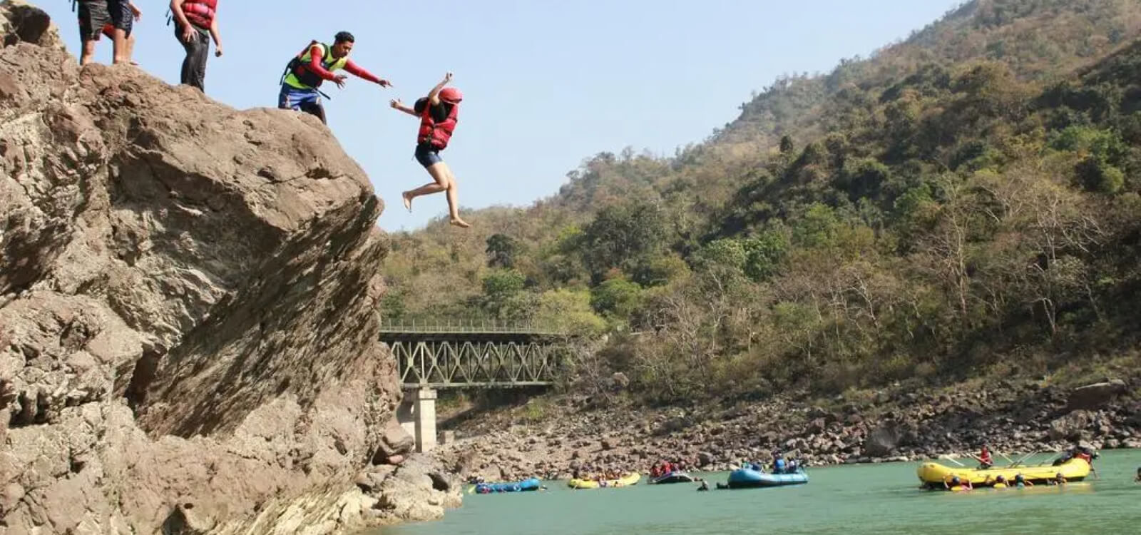 people enjoying cliff jumping around Pacific Inn - best riverside resort in rishikesh