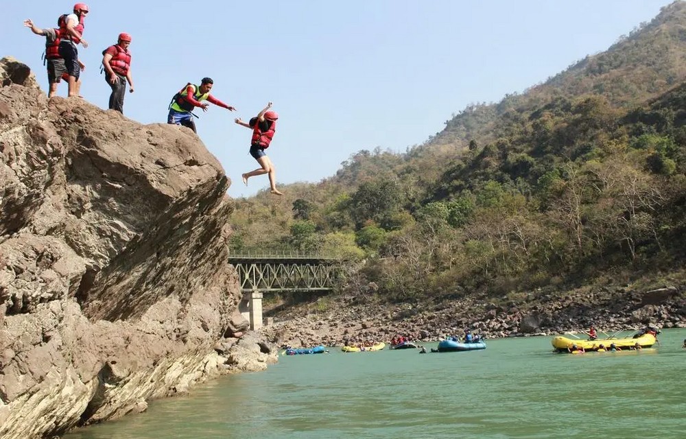 people enjoying cliff jumping around Pacific Inn - best riverside resort in rishikesh